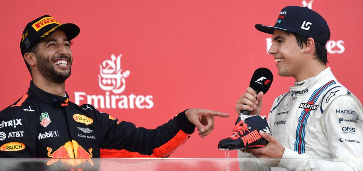 El australiano Daniel Ricciardo (i), ganador de la carrera, bromea con el canadiense Lance Stroll, quien se ubic&oacute; tercero, en el Gran Premio de Azerbaiy&aacute;n.