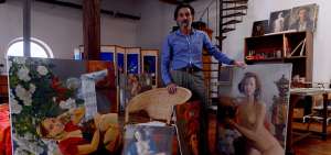 El artista posa frente a uno de sus cuadros en su taller de san marcos