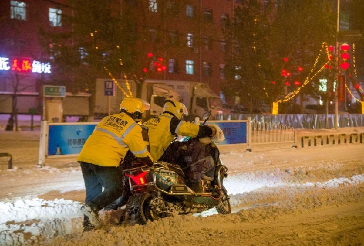 Los repartidores motorizados cumplen con sus entregas pese a las fuertes nevadas. 