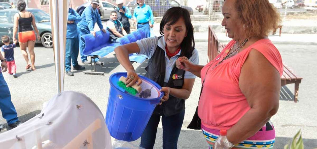 Karina Samaniego (i) explica la forma correcta de limpiar tanques y recipientes para evitar los criaderos. 