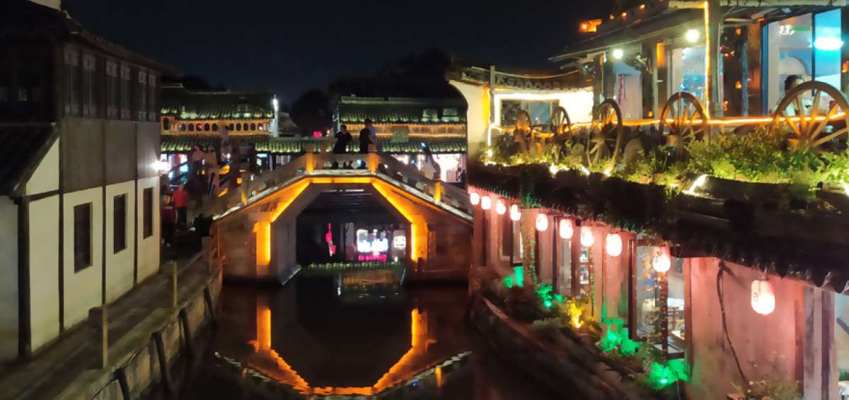 Luces de m&uacute;ltiples colores se encienden en Xitang, luego de caer el sol.