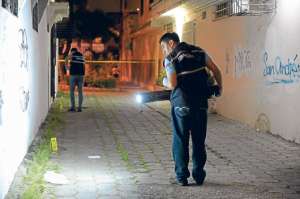 Los agentes de Criminal&iacute;stica de la Polic&iacute;a eval&uacute;an el lugar donde un joven falleci&oacute; por impactos de bala. Foto: Archivo / El Tel&eacute;grafo