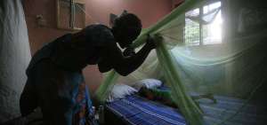 Una mujer instala un mosquitero sobre su hijo en Costa de Marfil. La OMS introducir&aacute; una nueva vacuna en tres pa&iacute;ses: Kenia, Ghana y Malaui. 