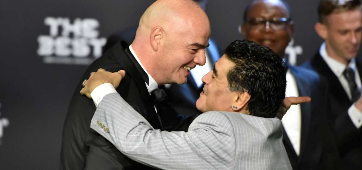 Maradona (der.) saluda a Gianni Infantino, a quien llam&oacute; traidor en &eacute;poca de elecciones en la FIFA.  