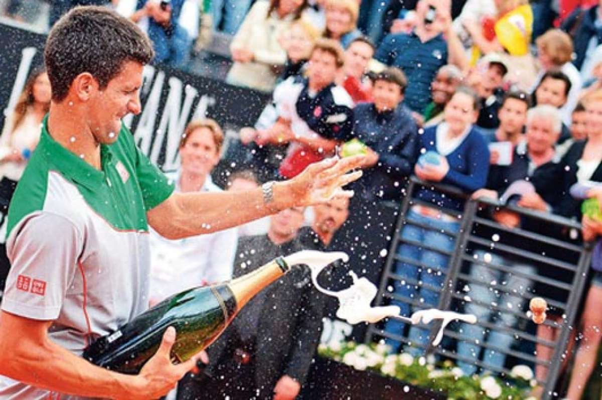 Djokovic celebra con champa&ntilde;a tras ganar el t&iacute;tulo; antes dibuj&oacute; con su raqueta un coraz&oacute;n sobre la pista central, agradeciendo al p&uacute;blico. Foto: EFE