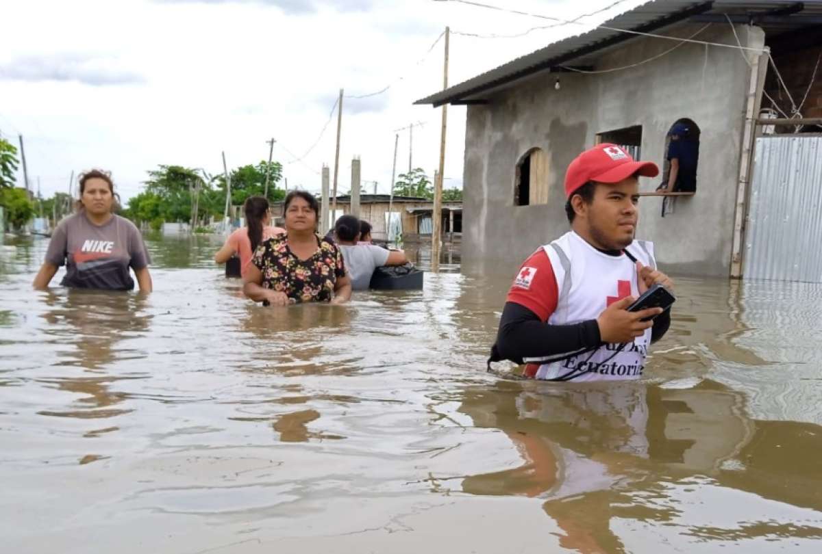 Ciudadanos y personal de Cruz Roja caminan por las calles inundadas
