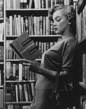 Marilyn Monroe en la biblioteca de su casa leyendo un libro de Arthur Miller, su esposo. Foto internet