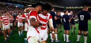 Los jugadores de la selecci&oacute;n de rugby de Jap&oacute;n celebran la clasificaci&oacute;n a los cuartos de final, un hecho in&eacute;dito para el pa&iacute;s; atr&aacute;s los rivales aplauden.