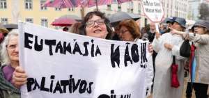 Una mujer sostiene una pancarta con el lema &ldquo;No a la eutanasia! S&iacute; a los paliativos!&rdquo; durante una manifestaci&oacute;n en la Asamblea de la Rep&uacute;blica.