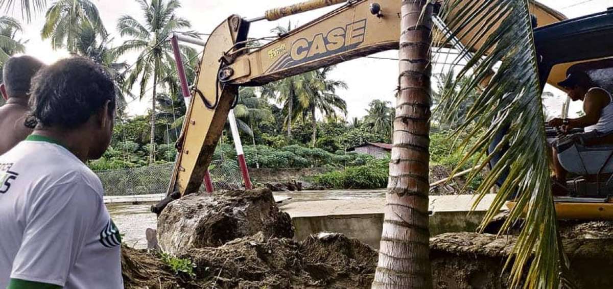 Una retroexcavadora retira el material p&eacute;treo con el fin de habilitar el acceso a un puente peatonal en la comunidad San Clemente (Manab&iacute;). 