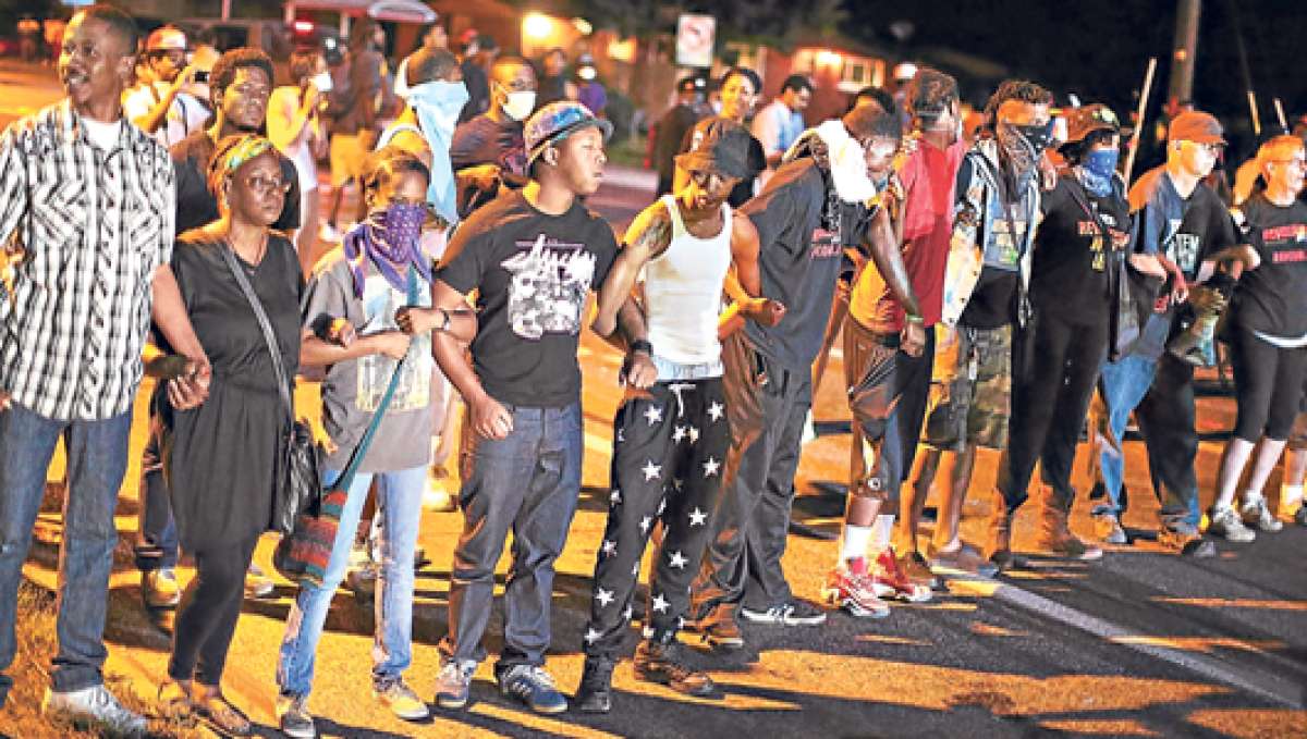 Los manifestantes organizaron un plant&oacute;n en la calle Ferguson en Misuri, EE.UU. En la noche la Polic&iacute;a lanz&oacute; gases lacrim&oacute;genos para dispersar a la gente. Foto: AFP