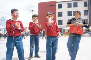 Una pr&aacute;ctica poco usual en Latacunga: un grupo de escolares compite animadamente con trompos. Foto: Silvia Osorio.