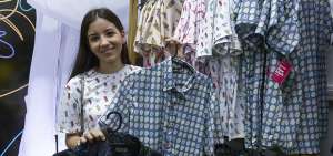 Valentina Juez, alumna de la Universidad Casa Grande, muestra los modelos de las camisas hechas con las empresas Tuenti y tambi&eacute;n con Indie.