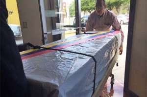 El ata&uacute;d que contiene el cuerpo de la menor migrante fue forrado con una lona blanca y sobre el mismo se coloc&oacute; la bandera del Ecuador. Foto: Cortes&iacute;a│El Diario MX