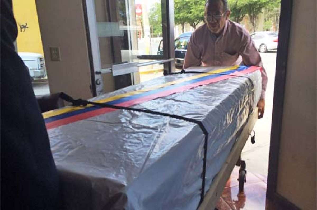 El ata&uacute;d que contiene el cuerpo de la menor migrante fue forrado con una lona blanca y sobre el mismo se coloc&oacute; la bandera del Ecuador. Foto: Cortes&iacute;a│El Diario MX