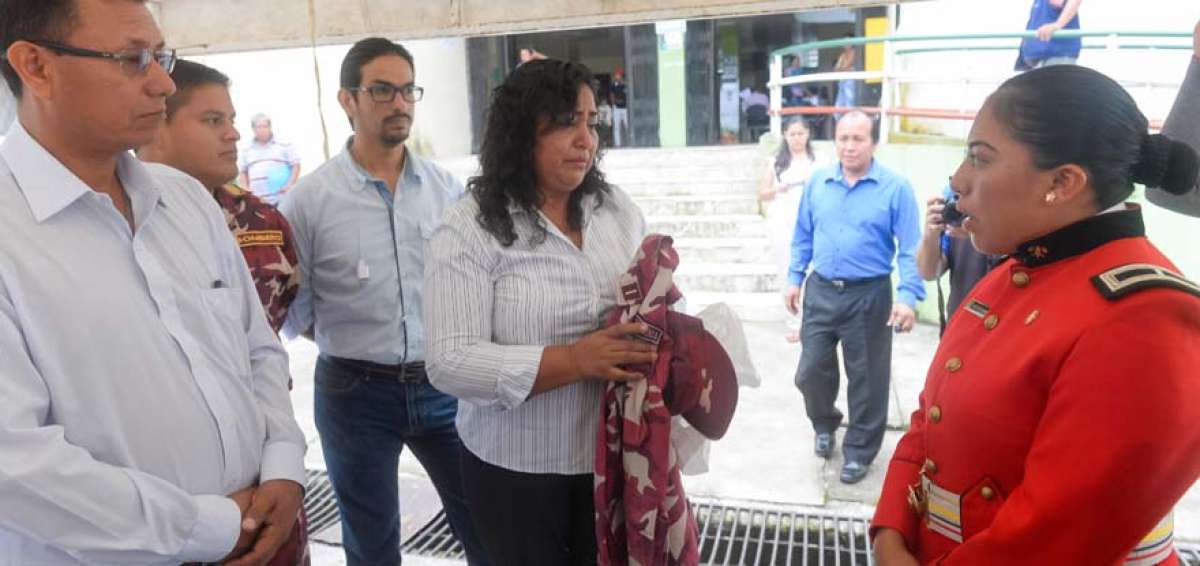 La subteniente Yessenia Iza Pilataxi recibe el uniforme de bombero de manos de su madre, Violeta Pilataxi. Jaime Shiguango, alcalde de Archidona (izq.), reintegr&oacute; a la mujer separada por discriminaci&oacute;n.  