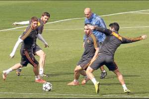 Zinedine Zidane (de azul) observa a los jugadores del Real Madrid durante una pr&aacute;ctica. Foto: EFE