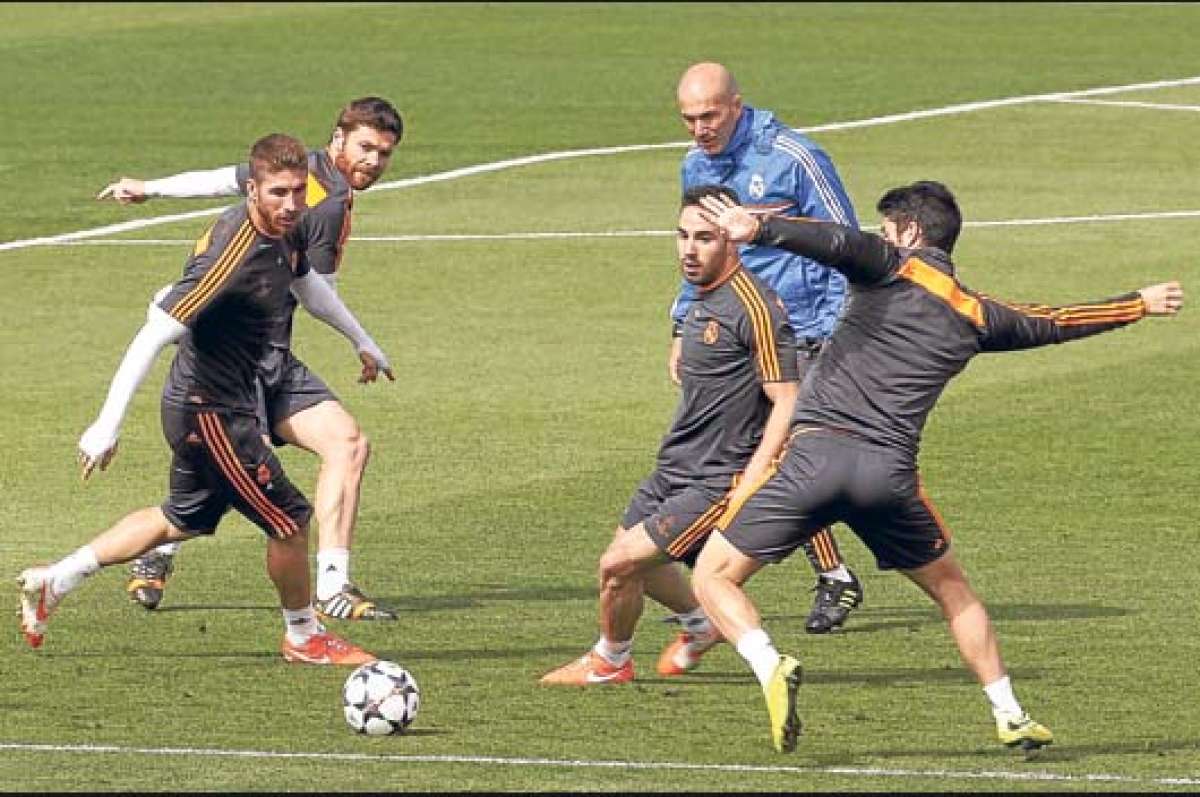 Zinedine Zidane (de azul) observa a los jugadores del Real Madrid durante una pr&aacute;ctica. Foto: EFE