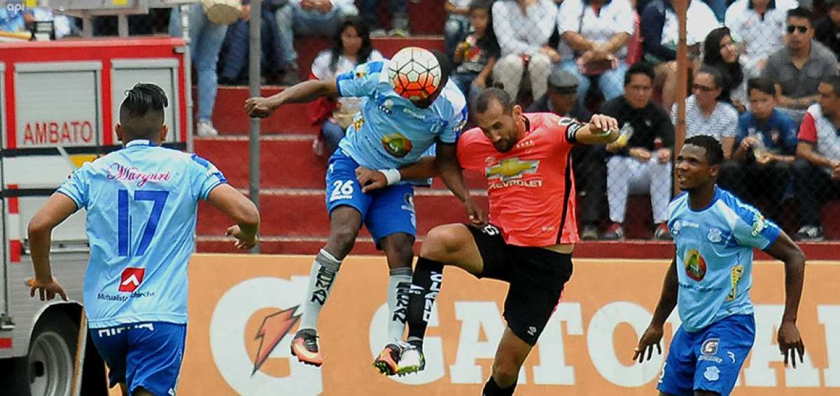 El delantero de Liga de Quito, Hern&aacute;n Barcos (c) intenta cabecear la pelota ante la marca de un defensa rival. 