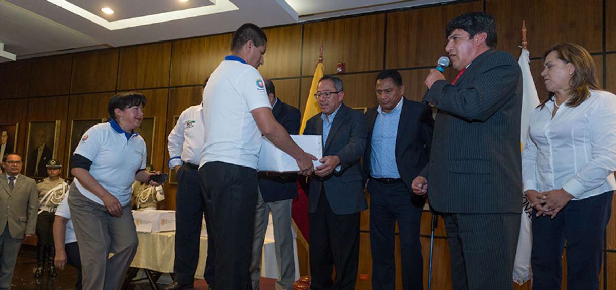 Wilmer Santacruz (derecha) explica la propuesta del sector, mientras el asamble&iacute;sta Augusto Espinosa recibe la documentaci&oacute;n.