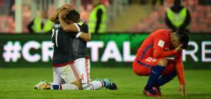 Dos jugadores paraguayos celebran el triunfo, mientras Gary Medel (d), defensa de Chile, se lamenta en cuclillas.     