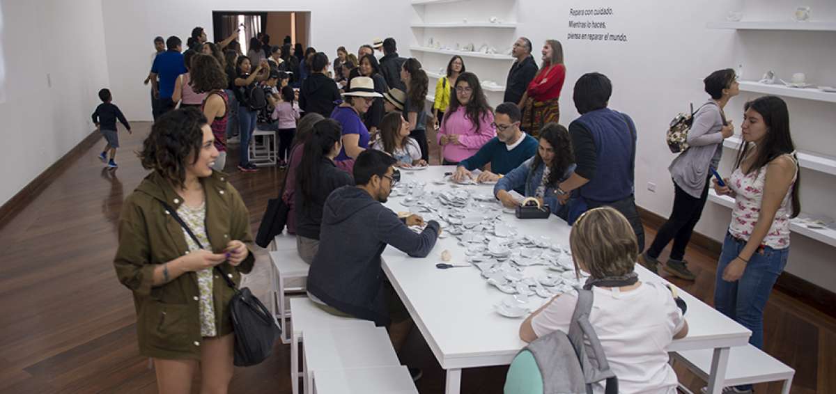 El p&uacute;blico durante el d&iacute;a de la inauguraci&oacute;n de la retrospectiva. En la gr&aacute;fica se aprecia la instrucci&oacute;n &ldquo;Repara con cuidado, piensa en reparar el mundo&rdquo;. 