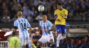 Neymar (der.) rechaza el bal&oacute;n de cabeza, ante la marca de dos volantes argentinos, la noche del viernes en el estadio Monumental de Buenos Aires. Foto: AFP
