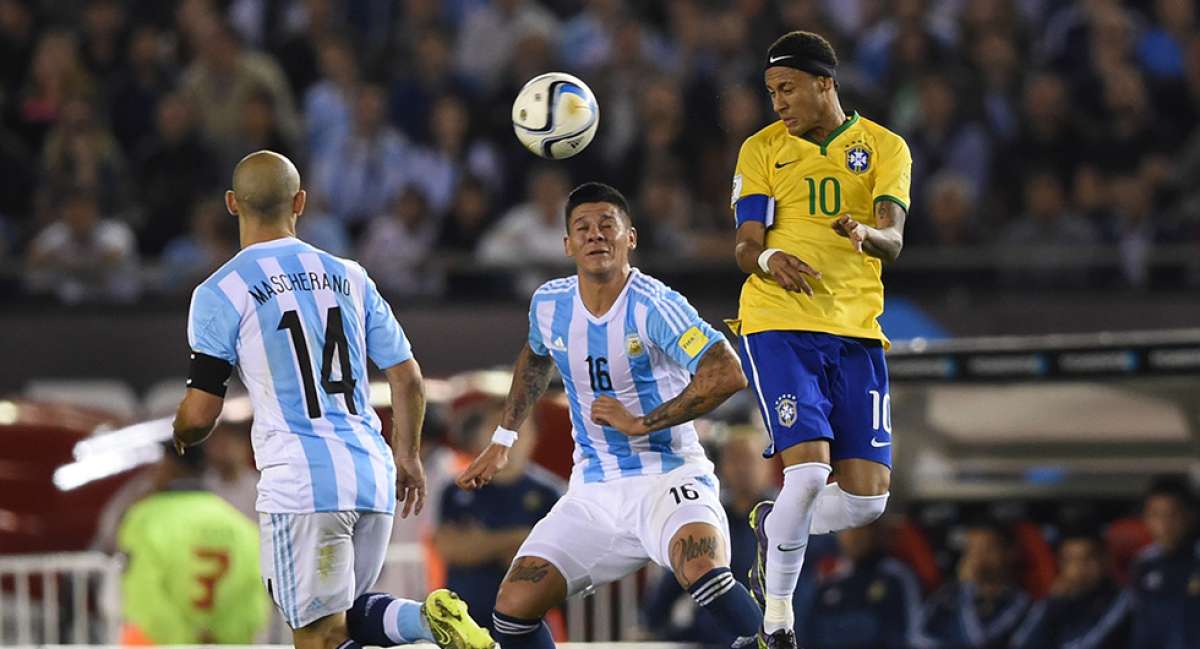 Neymar (der.) rechaza el bal&oacute;n de cabeza, ante la marca de dos volantes argentinos, la noche del viernes en el estadio Monumental de Buenos Aires. Foto: AFP