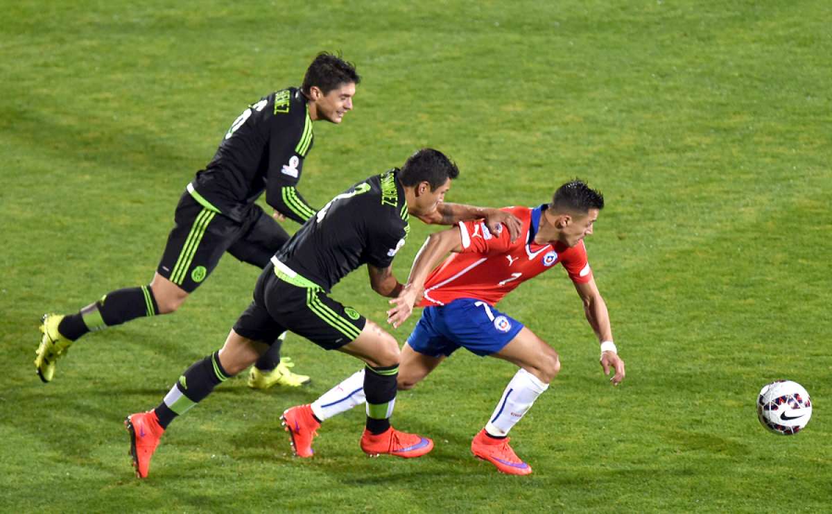 El chileno Alexis S&aacute;nchez (d.) intenta quitarse la marca del defensa mexicano Julio Dom&iacute;nguez (c); el volante Javier G&uuml;emez (i) acompa&ntilde;a la jugada. Foto: AFP
