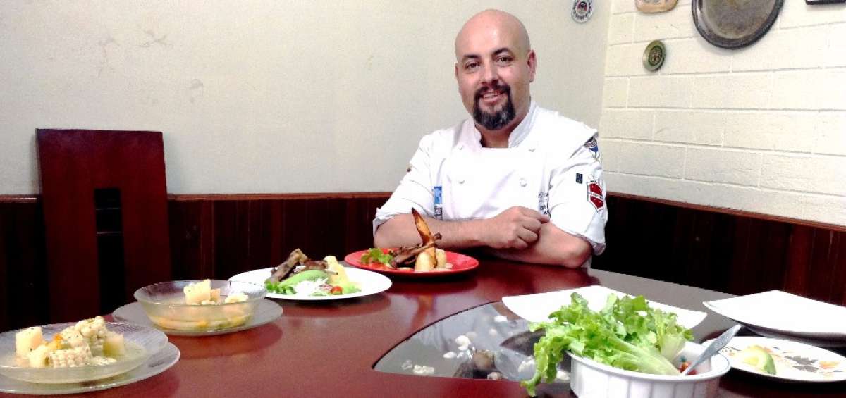 Ricardo Saltos muestra el sancocho de carne de llama y las chuletas asadas con salsa de man&iacute; y papas.