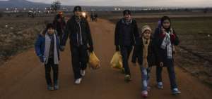 Una familia de migrantes cruza la frontera entre Macedonia y Serbia.