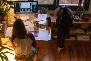 En la imagen de archivo, una mujer realiza teletrabajo en su casa mientras su hija juega a su lado.