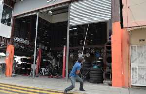 Los empleados de Tecnollantas JC procedieron a cerrar las puertas del local tras la orden del Comisario. Foto: William Orellana / El Tel&eacute;grafo