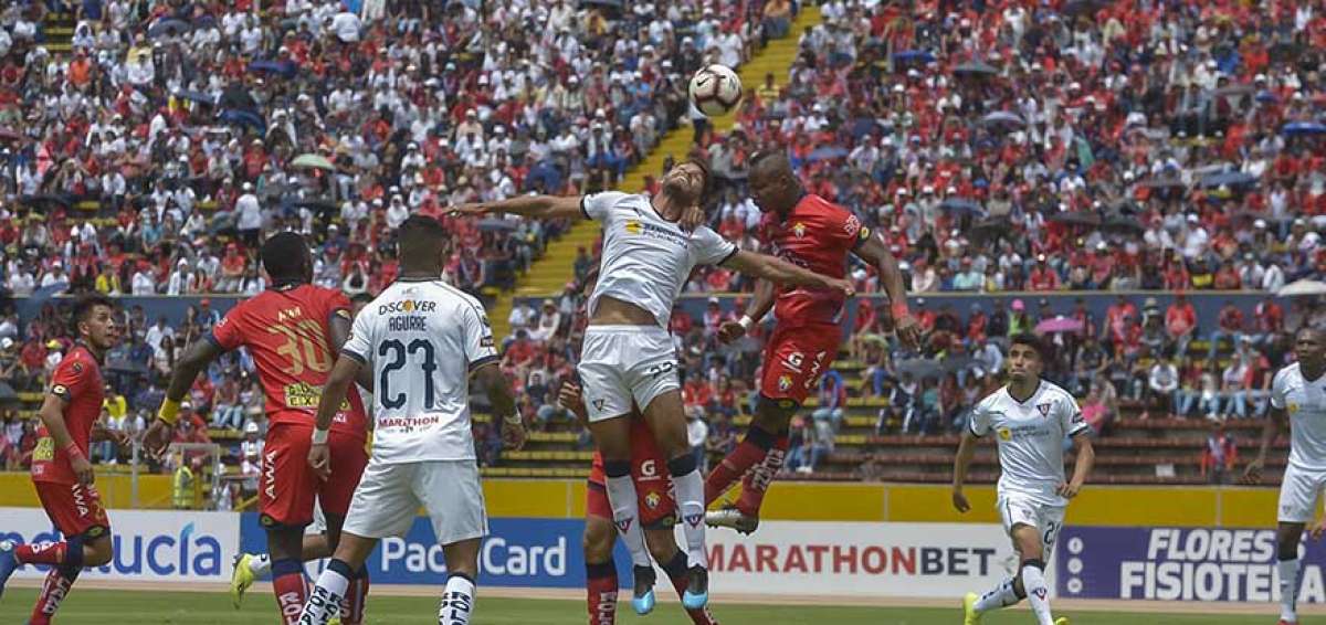Los jugadores de El Nacional (rojo) y Liga de Quito, disputan el bal&oacute;n en el partido de la fecha 9, disputado ayer en el estadio Ol&iacute;mpico Atahualpa.