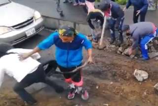 Manifestante empuja a una mujer al tratar de habilitar el paso vehicular