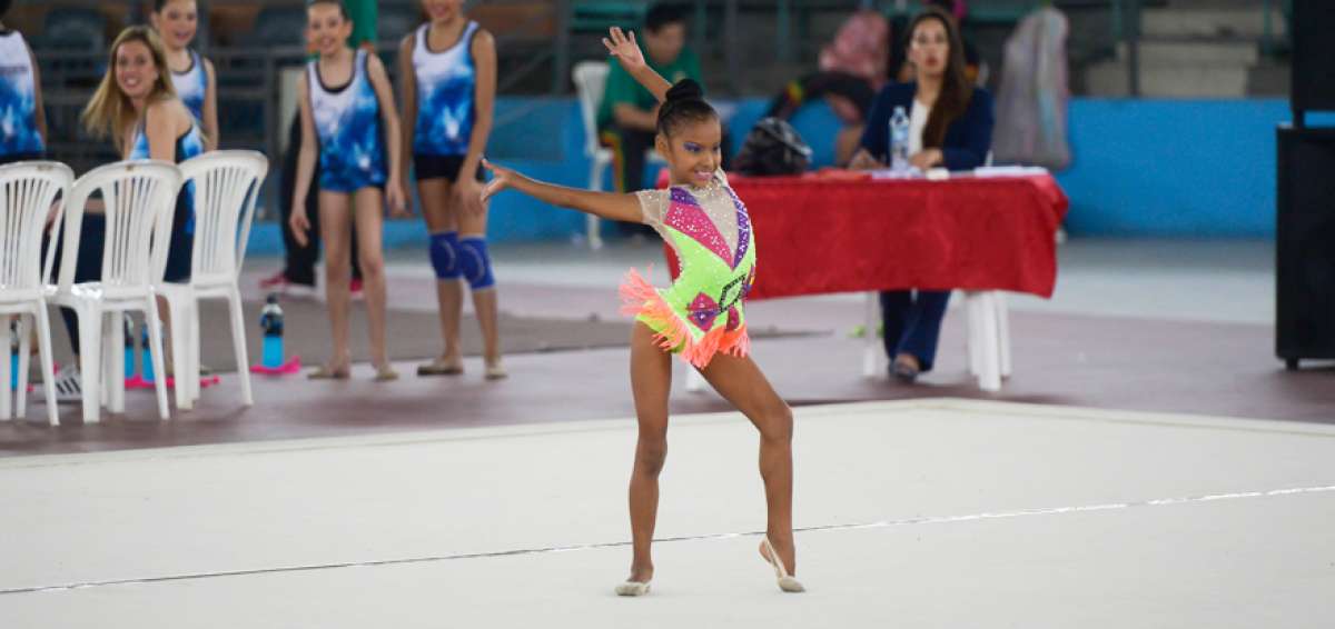 Emily Ch&aacute;vez, de Ecuador, durante su segunda rutina en la final. Atr&aacute;s observan la jueza y otras participantes.