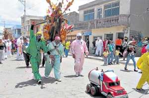 Danzantes del barrio San Felipe,durante los festejos, desfilan cargando un cerdo asado. Foto: Silvia Osorio