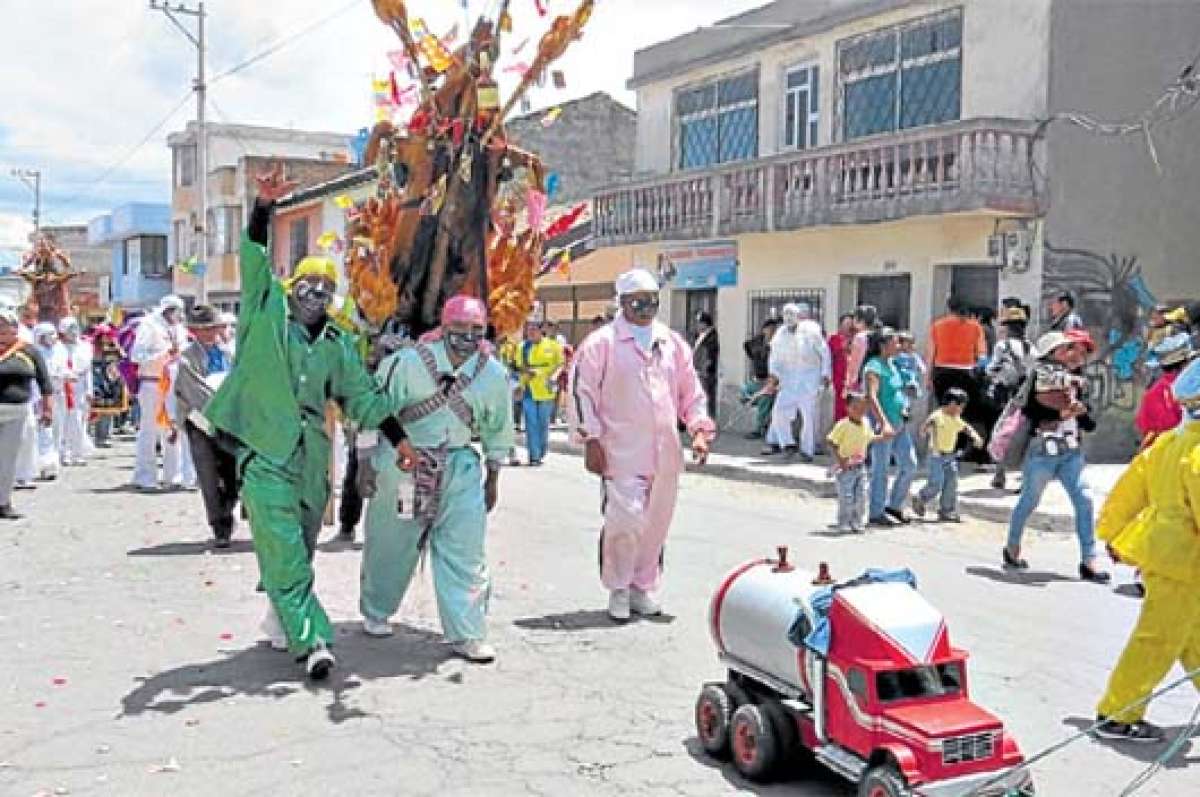 Danzantes del barrio San Felipe,durante los festejos, desfilan cargando un cerdo asado. Foto: Silvia Osorio