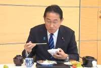 Fumio Kishida demostrando que la comida de su mar es segura