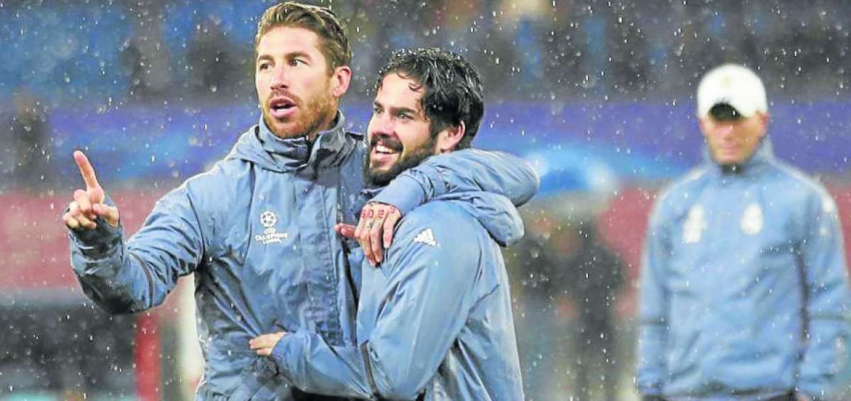 Isco (centro) se abraza con Sergio Ramos durante un entrenamiento del Madrid. Atr&aacute;s los observa Zidane. 