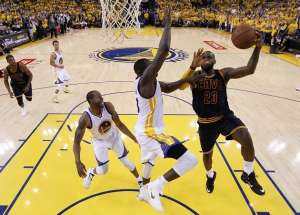 Lebron James (der.) intenta encestar ante la presi&oacute;n de Draymond Green de Golden State. FOTO: AFP