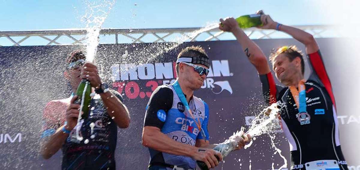 Tim Rea, ganador del Ironman 70.3 de Manta, festeja junto a los deportistas que quedaron en segundo y tercer lugar en la competencia.