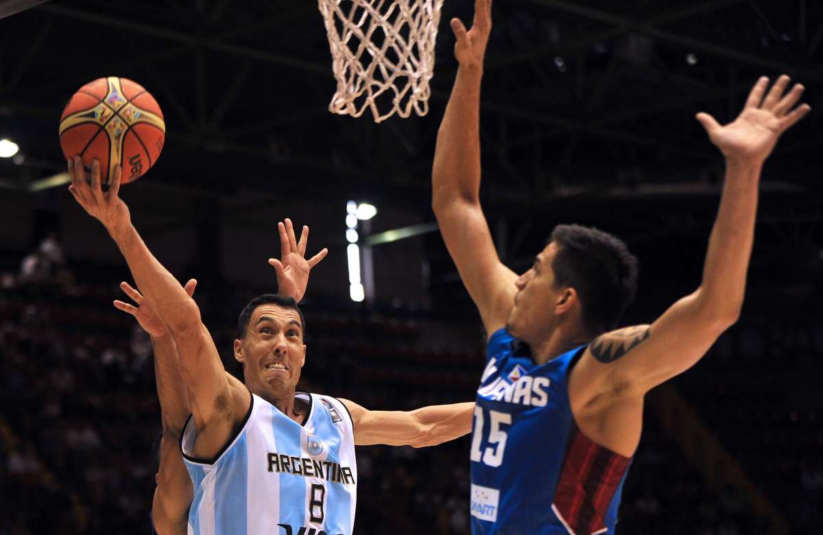 Pablo Prigioni (i.) lanza el bal&oacute;n ante la marca de un jugador filipino. Foto: AFP