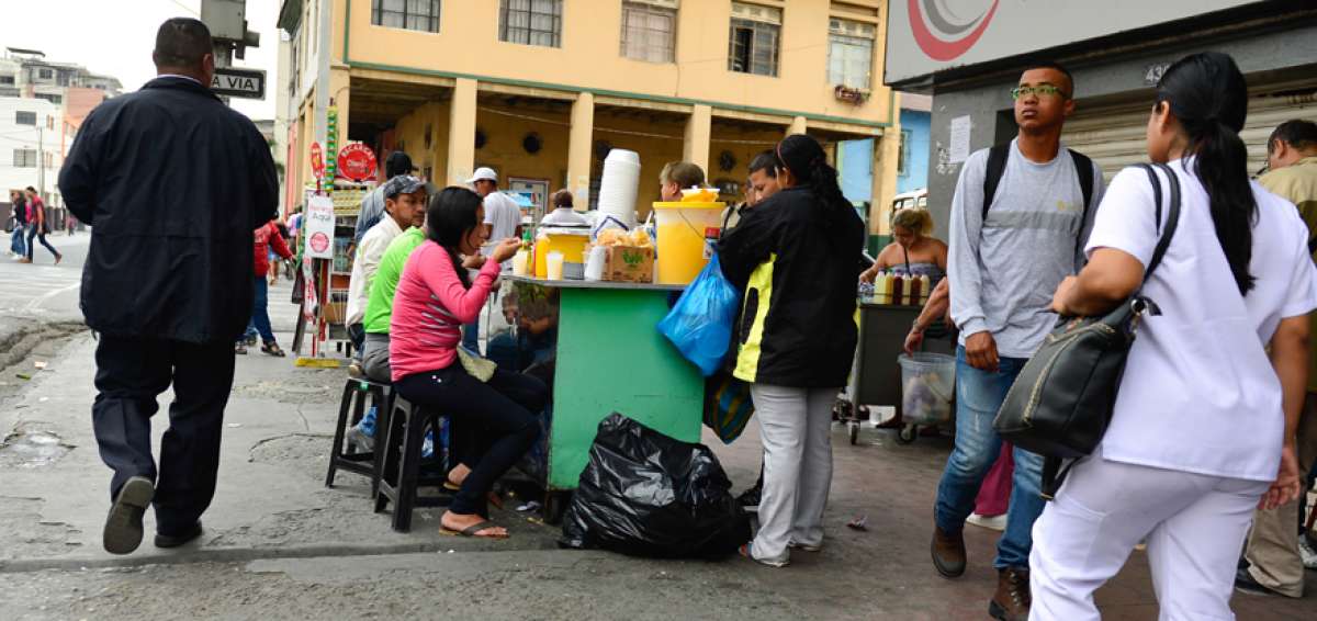 Los transe&uacute;ntes consumen varios alimentos en los puestos improvisados que prosperan en la calle Jos&eacute; de Antepara.