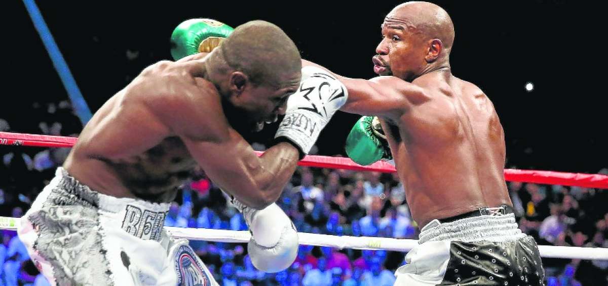 El pugilista estadounidense (d) estar&iacute;a planificando la pelea ante el campe&oacute;n de la UFC, Conor McGregor, que le dejar&iacute;a unos $ 100 millones.