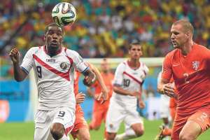 Joel Campbell (iz.) de Costa Rica intenta dominar el bal&oacute;n ante la marca del defensor holand&eacute;s Ron Vlaar (d.). Foto: AFP.