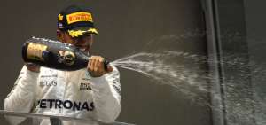 Lewis Hamilton festeja con champagne tras alcanzar el podio de la decimacuarta carrera de la temporada.