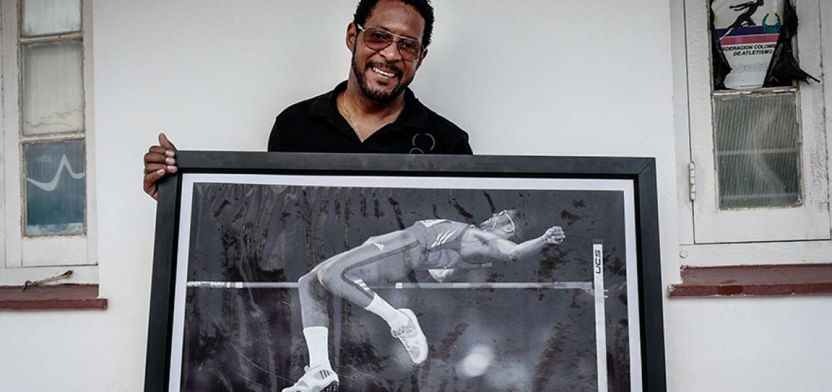 Javier Sotomayor posa en su casa en La Habana con la foto que inmortaliz&oacute; el momento en que logr&oacute; la hasta hoy imbatible marca mundial en salto alto con un registro de 2,45 metros.