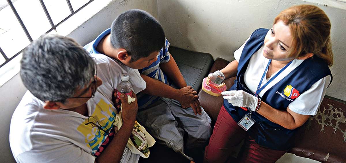 Yasira Minchala (d), integrante de los EAIS, atiende a un paciente con par&aacute;lisis cerebral en el sector del Cristo del Consuelo, suroeste de Guayaquil.