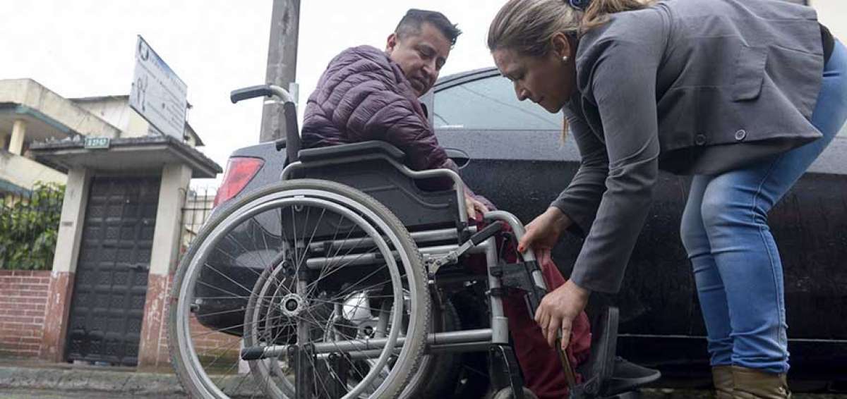 Ana Vivanco le ayuda a su esposo, Hugo Galarza, a salir del veh&iacute;culo que lo llev&oacute; hasta su casa en el sur de Quito.